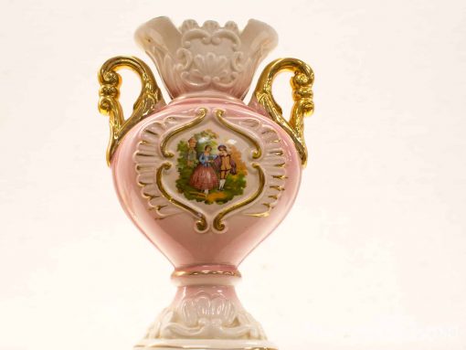 Elegant pink ceramic vase with pastoral scene, golden handles, and ruffled white rim.