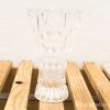 Elegant crystal vase with diamond cuts, resting on rustic wood, perfect for floral displays.