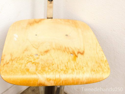 Modern wooden chair with metallic frame, featuring a stylish honey-toned seat.