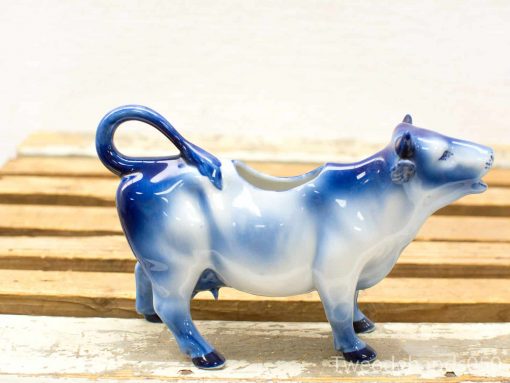 Charming blue and white ceramic cow creamer, perfect for serving milk or cream.