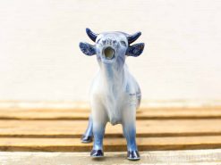 Charming blue and white porcelain cow figurine, perfect for collectors and home decor.