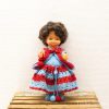 Charming vintage doll in colorful crocheted dress, evoking nostalgia and childhood joy.