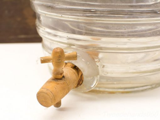 Vintage glass beverage dispenser with wooden tap, perfect for rustic kitchen settings.
