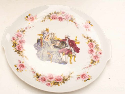 Elegant decorative plate featuring pink roses and 18th-century figures, perfect for collectors.