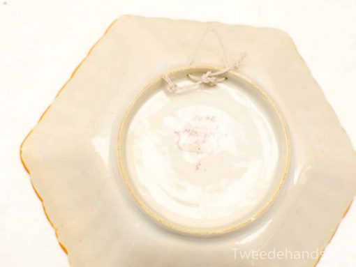 Elegant hexagonal porcelain plate with gold trim, perfect for display or functional use.