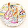 Elegant porcelain plate with hand-painted traditional East Asian figures in vibrant colors.