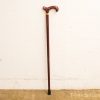Elegant vintage red cane with curved handle and yellow band for added support and style.
