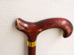 Elegant vintage cane with curved hardwood handle and stylish gold accent.