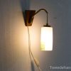 Stylish wall-mounted lamp with wood and glass, blending modern design and retro charm.