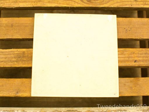 Elegant cream tile on rustic wooden surface, highlighting minimalism and craftsmanship.