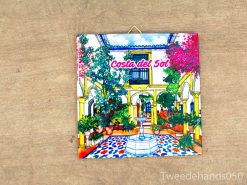 Charming Spanish courtyard fountain surrounded by vibrant flowers and lush greenery.