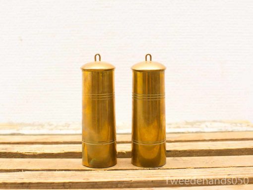 Elegant brass containers with smooth finishes and decorative engravings on a wooden surface.