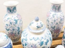 Beautiful traditional Asian ceramic vases and jar adorned with floral patterns in blue and green.