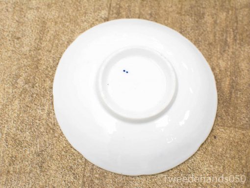 Elegant porcelain dish with unique blue markings, showcasing exquisite craftsmanship and timeless beauty.