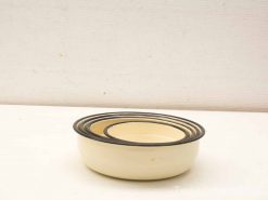 Vintage enamel nesting bowls with black rims, perfect for cooking and serving in any kitchen.