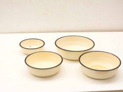 Charming vintage round bowls with creamy yellow interiors and black rims, perfect for any kitchen.