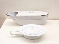 Charming vintage enamelware baking dish and bowl set with blue rims, perfect for retro decor.