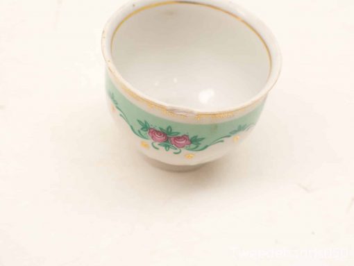 Elegant porcelain teacup with turquoise band, floral motif, and luxurious gold accents.