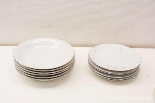 Elegant white plate set for stylish dining, featuring six large and three small plates.