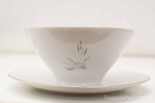 Elegant hand-painted porcelain bowl and saucer with floral designs and subtle gold detailing.