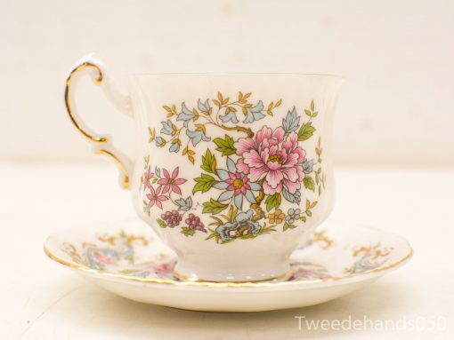 Elegant vintage porcelain teacup and saucer set with vibrant floral patterns and gold accents.