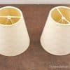 Elegant off-white lamp shades on a rustic wooden surface, enhancing cozy home decor.