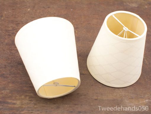 Elegant white lampshades with textured design on rustic wooden surface, perfect for any decor style.