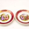 Vintage decorative plates featuring classical scenes, rich pink edges, perfect for display or collection.