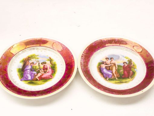 Vintage decorative plates featuring classical scenes, rich pink edges, perfect for display or collection.