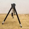 Stylish vintage aluminum camera tripod with adjustable legs and quick-release mechanism for stability.