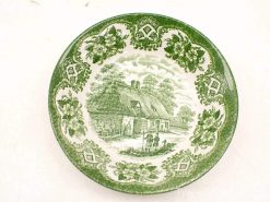 Charming ceramic plate with green floral patterns and a quaint cottage scene, ideal for collectors.