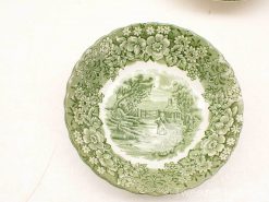 Charming vintage decorative plate featuring a pastoral scene and delicate floral designs in green.