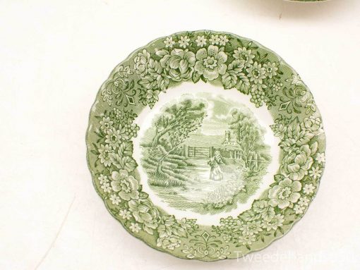 Charming vintage decorative plate featuring a pastoral scene and delicate floral designs in green.