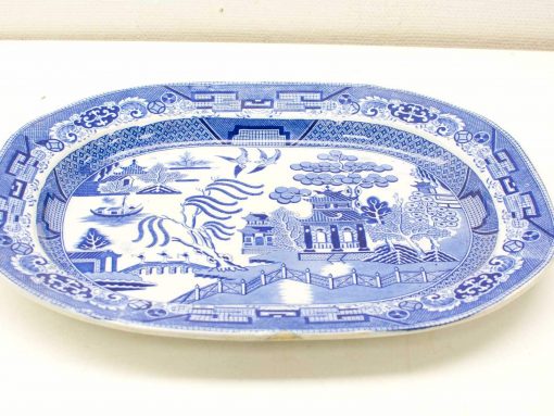 Ornate blue and white platter featuring a scenic landscape, trees, and a bridge design.