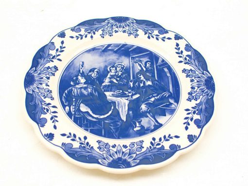 Decorative blue-and-white plate featuring a joyful gathering and intricate floral border.