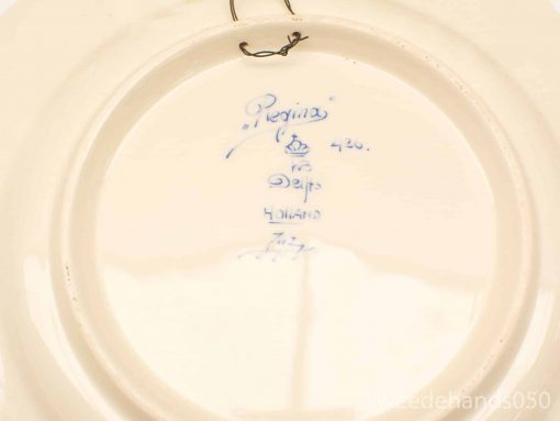 Elegant Regina Delft-style ceramic plate with wall hook and decorative blue ink stamp.