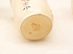 Elegant porcelain vase featuring hand-painted pink flowers and green leaves, perfect for decor.