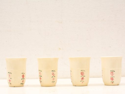 Vintage floral ceramic cup set, elegant cream glaze with pink flowers and green leaves.