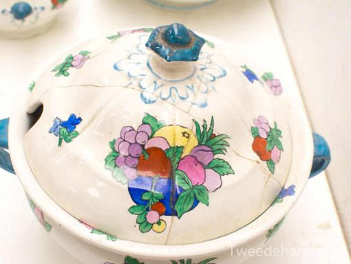 Vibrant handcrafted ceramic pot with decorative lid, featuring floral designs and a charming blue knob.