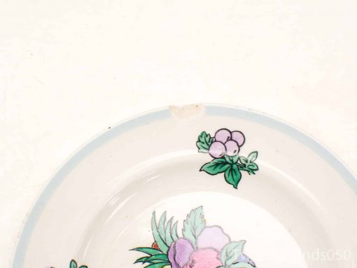 Vintage ceramic floral plate with charming design and minor chip, perfect for display or use.