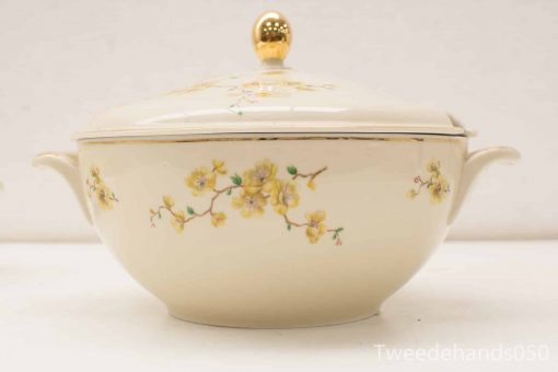 Elegant ceramic serving dish with floral design and gold accents for refined dining occasions.