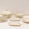 Elegant porcelain dining set with floral design, features serving dish, bowls, gravy boat, and platters.