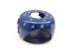 Vibrant blue ceramic plant holder with hand-painted white floral design for home decor.