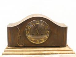 Elegant vintage mantel clock in dark wood with gold accents for timeless home decor.