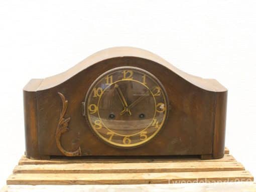 Elegant vintage mantel clock in dark wood with gold accents for timeless home decor.