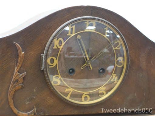 Elegant antique wooden clock with glass face and gold accents, perfect for vintage decor.