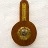 Antique wooden barometer and thermometer with vintage charm and elegant craftsmanship.