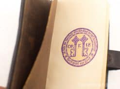 Vintage book Sleutels van Dood en Abyss with purple key stamp, rich in history.