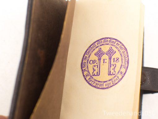 Vintage book Sleutels van Dood en Abyss with purple key stamp, rich in history.