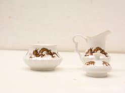 Elegant porcelain tea set with dragon motif, featuring bowl, pitcher, and lidded container.